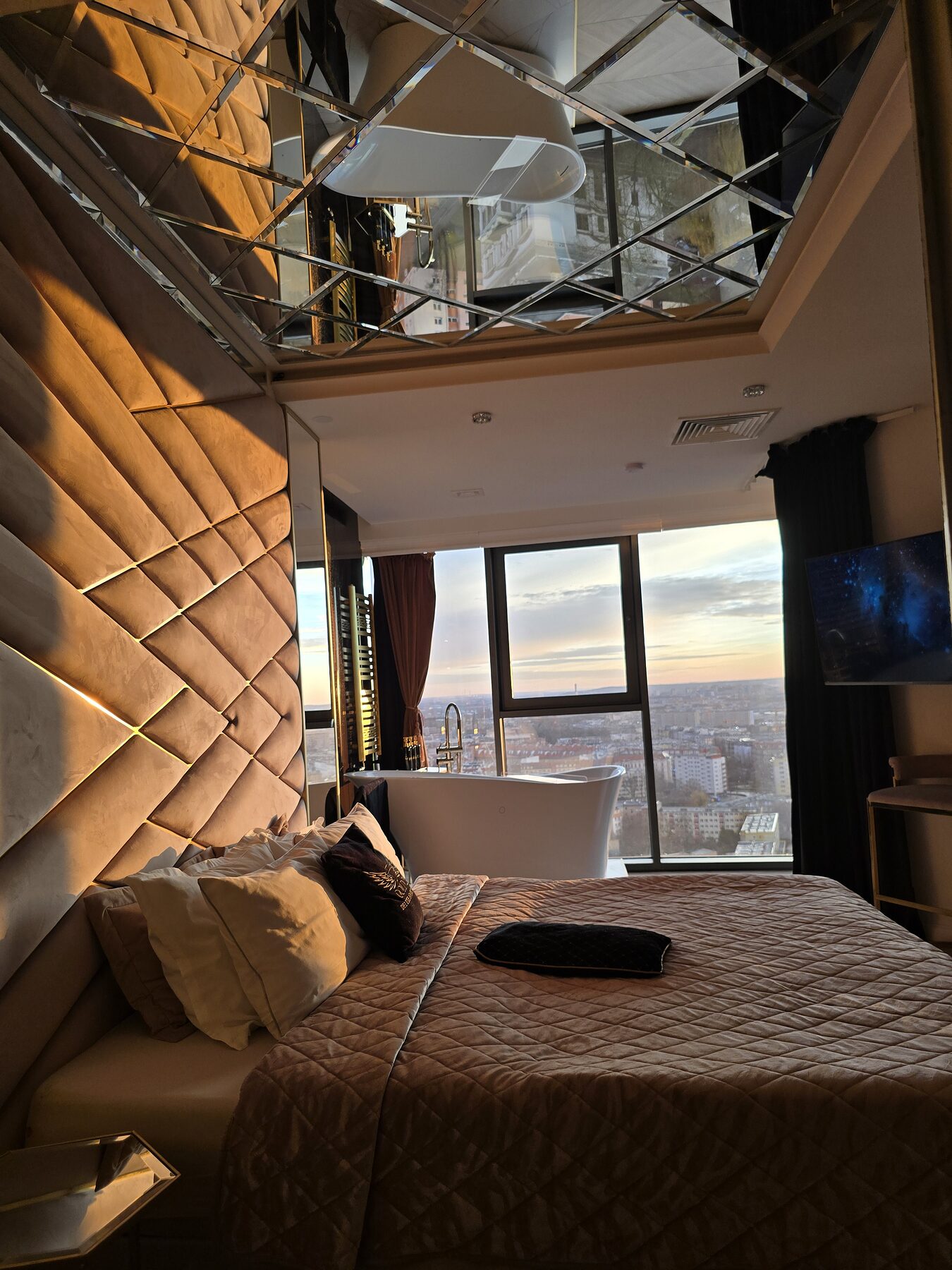 Wiszacy fotel przy panoramicznych oknach o zachodzie slonca